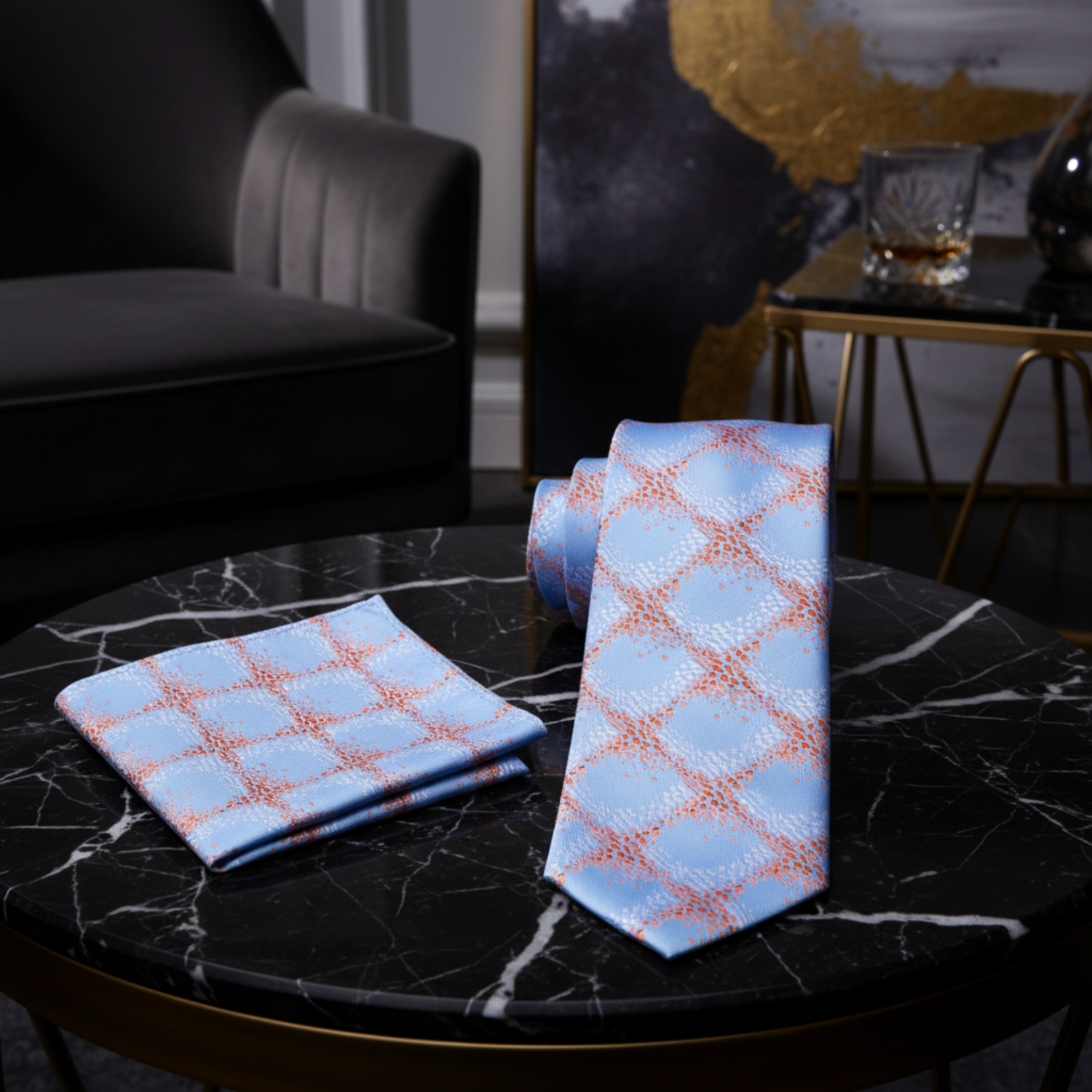 Blue tie with orange geometric pattern and matching pocket square on a white background