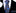 Black suit with a blue polka dot tie and matching pocket square on a white background