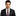 Man wearing a black suit with a patterned tie and pocket square on a white background