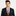 Man wearing a black suit with a red and black patterned tie and matching pocket square on a white background