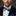 Man wearing a black suit with a colorful bow tie against a dark background