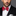 Man wearing a black suit with a red bow tie on a gray background