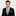 Man wearing a black suit with a purple checkered tie and pocket square on a light gray background
