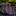 Rolled-up tie with black, pink, and gray stripes on a dark surface with blurred flowers in the background