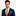 Man wearing a navy suit with an orange striped tie and pocket square on a light gray background