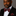 Man wearing a black suit with a red paisley bow tie and pocket square on a gray background