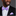 Man wearing a black suit with a colorful light purple and light blue floral bow tie and pocket square on a gray background