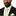 Man wearing a black suit with a white shirt and green and white striped tie on a white background
