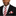 Man wearing a black suit with a red and white striped tie and pocket square on a white background