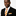 Man wearing a black suit with an orange and white striped tie on a plain background