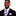 Man wearing a black suit with a purple polka dot tie and pocket square on a white background