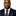 Man wearing a navy suit with a polka dot tie and pocket square on a white background
