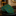 Green patterned polka tie on a dark surface with a blurred background