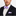 Man wearing a black suit with a white shirt and purple striped bow tie and pocket square.