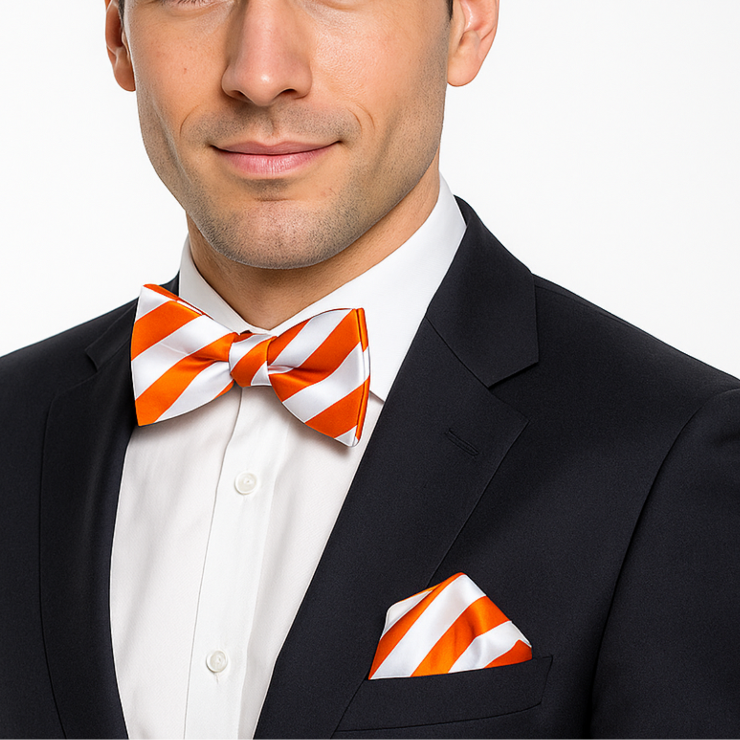 Man wearing a black suit with an orange and white striped bow tie and pocket square on a white background