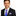Man wearing a black suit with a blue tie and purple pocket square on a white background