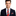 Man wearing a dark suit with a red and gray striped tie on a white background