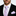 Man wearing a black suit with a pink and blue checkered tie and pocket square.
