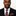 Man wearing black suit with black, gold purple and brown diamonds necktie and square