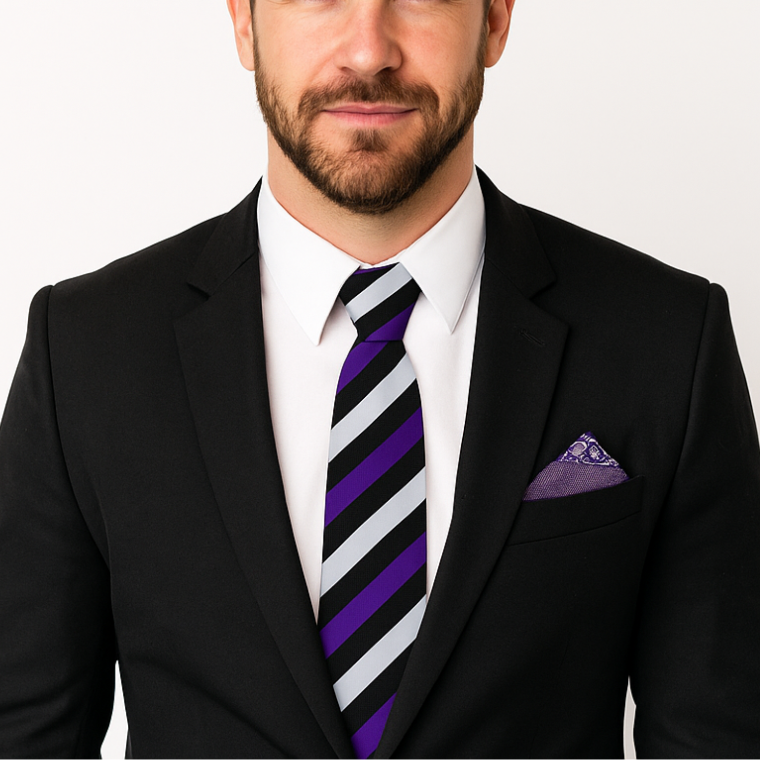 Man wearing a black suit with a purple and white striped tie on a white background