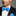 Man wearing a black suit with a light blue bow tie and matching pocket square on a gray background