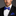Man wearing a black suit with a white shirt and blue bow tie and pocket square.