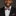 Man wearing a black suit with a colorful bow tie and pocket square on a dark background