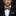 Man wearing a black suit with a blue and orange patterned bow tie and pocket square.