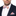 Man wearing a navy suit with a peach and purple paisley patterned bow tie and pocket square on a white background