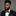 Man wearing a black suit with a colorful bow tie and pocket square on a gray background