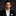 Man in a black suit with a yellow bow tie and pocket square on a dark background