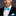 Man wearing a black suit with a electric blue bow tie and pocket square on a gray background