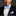 Man wearing a black tuxedo with a blue bow tie and pocket square on a dark background