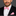 Man wearing a black suit with a pink bow tie and pocket square on a gray background