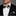 Man wearing a black suit with a Green, Yellow, White Stripe Bow Tie and Square