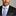Man wearing a black suit with a Light Blue, Grey Geometric Necktie and Accenting Stripe Square