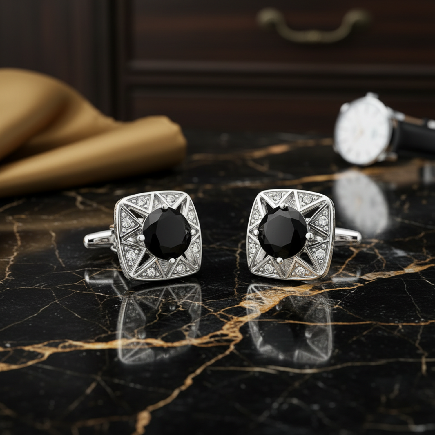 Pair of silver cufflinks with black gemstones on a dark marble surface