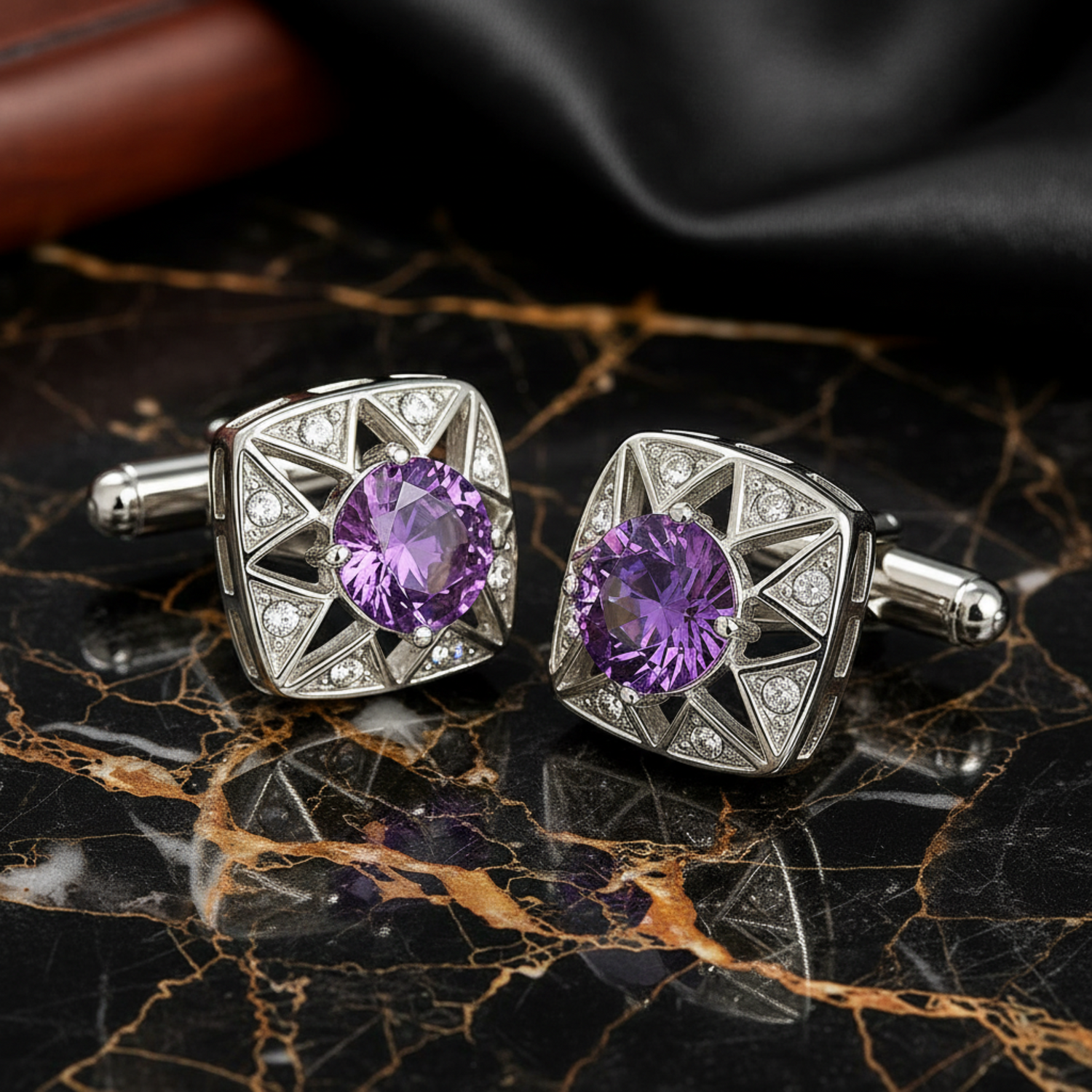 Pair of silver cufflinks with purple gemstones on a black marble surface