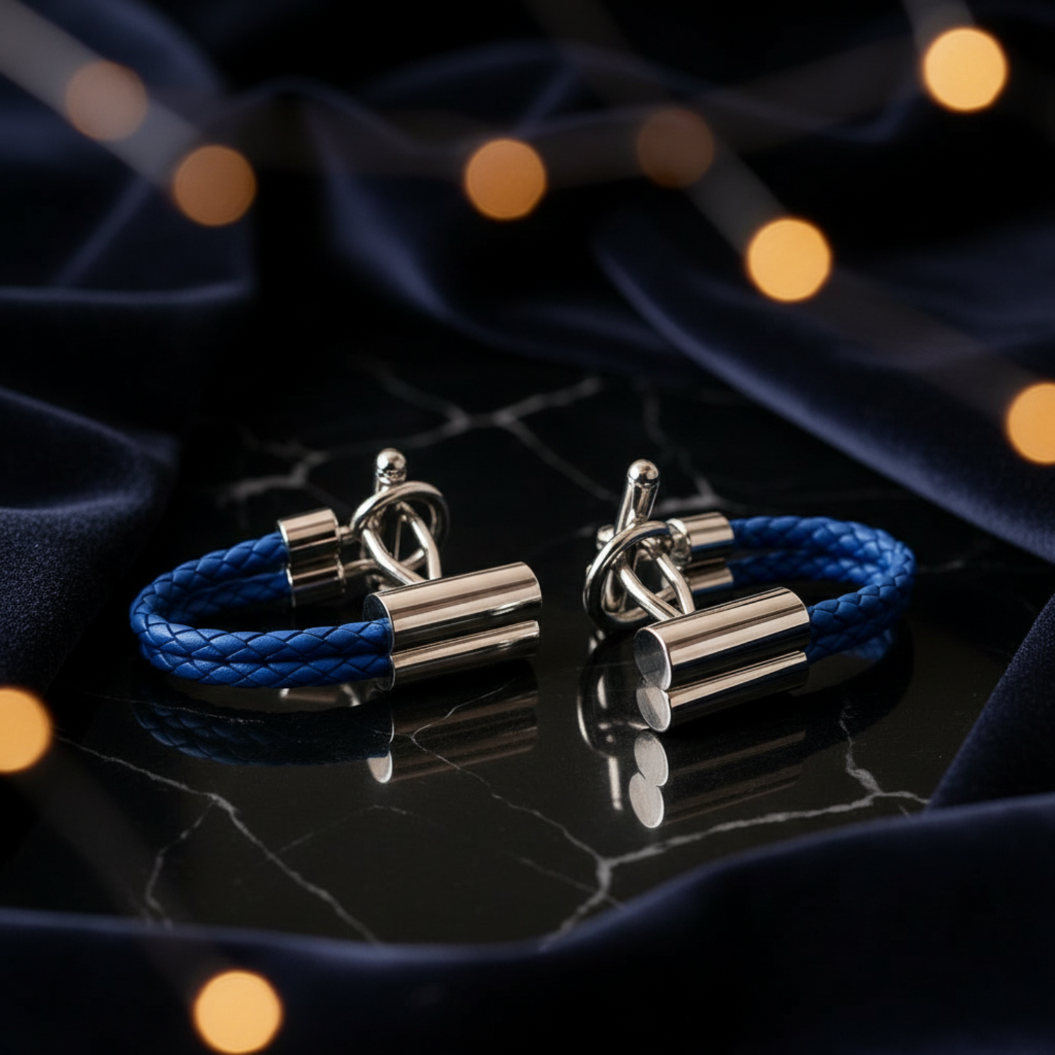 Two blue braided bracelets with silver clasp on a dark textured surface