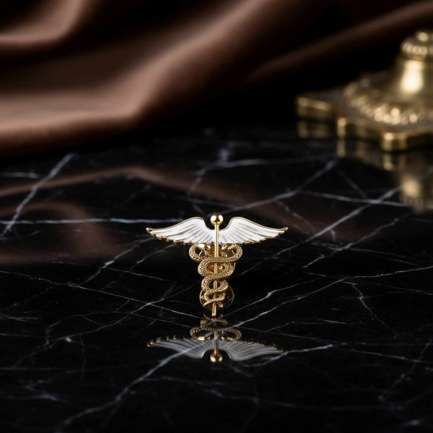 Gold caduceus symbol with wings on a black marble background