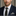 Man wearing a navy suit with a patterned tie and pocket square against a neutral background