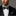 Man wearing a black suit with a Green, Brown and Grey Check Bow Tie and Pocket Square on a gray background