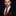 Man wearing a black suit with a Red, Black Abstract Necktie and Abstract Square against a dark background