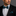 Man wearing a black suit with a Black, Teal Lines Bow Tie and Pocket Square against a gray background