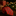 Red tie with green Christmas tree patterns on a wooden surface with blurred lights and presents in the background