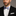 Man wearing a black suit with a white shirt and a blue striped bow tie on a gray background