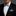 Man wearing a black tuxedo with a white shirt, blue patterned bow tie, and matching pocket square.
