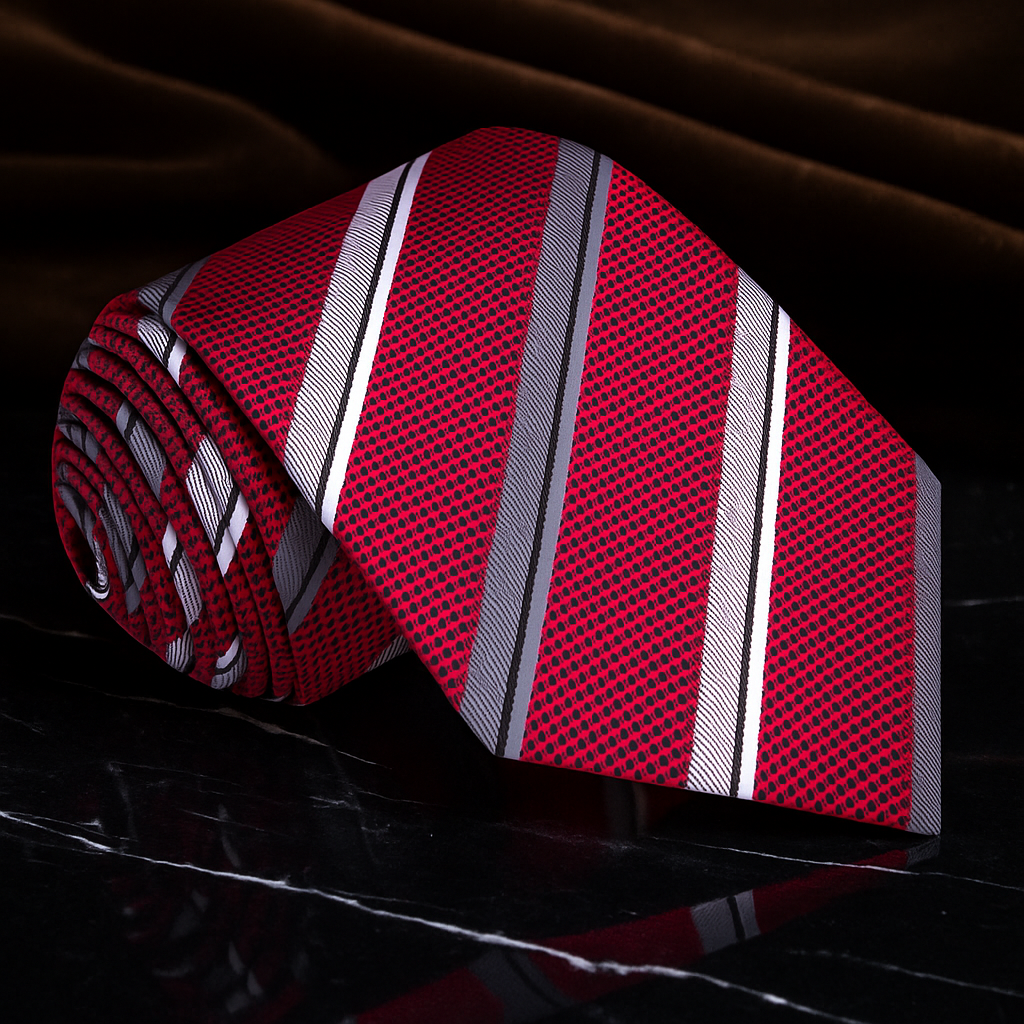 Red striped tie on a dark fabric background