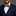 Man wearing a navy suit with a colorful bow tie against a gray background