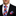 Man wearing a black suit with a colorful checkered tie and pocket square on a white background